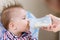 Mother feeds baby from a bottle of milk