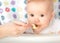 Mother feeds funny baby from spoon
