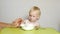 Mother feeds her baby oatmeal, close-up, child nutrition, breakfast