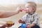 Mother feeds  small child with fruit puree