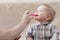 Mother feeds  small child with fruit puree