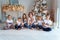 Mother and five children playing sparkler near Christmas tree at home