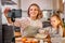 mother food blogger records the process of cooking with daughter on smartphone's camera
