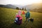 Mother with four kids in the grass gorgeous mountain range in the horizon