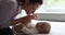 Mother gently kissing little feet, tiny toes of newborn baby