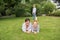 Mother and girl on the grass, small boy in the background