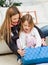 Mother And Girl Opening Christmas Present