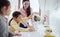 Mother with girls indoors at home, preparing fruit smoothie drink.