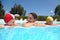 Mother and girls lie near skirting in pool