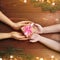 Mother gives a child a gift on a wooden background