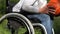 Mother gives a son his ball and smile sitting in a wheel chair.