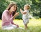 Mother giving child flower in the park