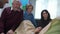 Mother, grandfather and other relatives sit and talk to girl who lie on the bed in the hospital