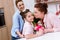 mother and grandmother presenting gift and flowers to daughter