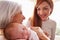 Mother And Grandmother With Sleeping Newborn Baby Daughter