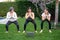 Mother, grandmother and teen daughter practicing fitness lesson online outdoors