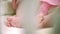 Mother hand touching infant baby foot. Family tenderness. Maternity care