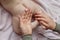 Mother hands applying cream on baby after bathing in room. hands of a mother massaging her baby`s feet, in bed at home