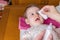 Mother hands cleaning eyes of baby with cotton