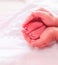 Mother hands holding infant feet sleeping