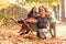 Mother have fun time with kids, use garden wheelbarrow with pumpkins