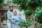 Mother in headscarf guides daughter to use plant shears