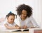 Mother helping daughter do homework in workbook