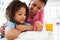 Mother Helping Daughter With Homework In Kitchen