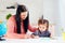 Mother helping daughter to develop writing skills at home