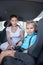 Mother helping daughter to fasten car safety belt