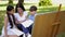 Mother helping her kids with school work in the park.