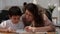 Mother helping her son with his homework surrounded by mathematical symbols