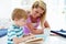 Mother Helping Son With Homework In Kitchen