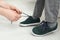 Mother helping son to tie shoe laces at home, closeup