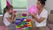 Mother helps daughter blow balloons