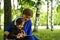 Mother helps her daughter with distant education outside in the park.