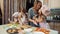 Mother helps her daughters to decorating the cookies with glaze.