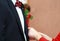 Mother helps her son who is the groom to wear his wedding corsage on groom`s suit