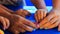 Mother helps kid sculpture of pink plasticine on blue table