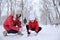 Mother with her child building small snowman outside on winter day. Christmas vacation