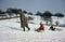 A mother and her children go tobogganing in winter. 1960s, Germany.