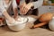 Mother and her daughter are baking a bread and having fun at the kitchen.