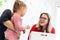 Mother and her daughter in child occupational therapy session doing sensory playful exercises with the child therapist.