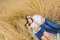 Mother with her daughter lies in a wheat field in summer. Solitude of the mother with the child.