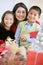 Mother With Her Family Holding Christmas Gifts