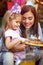 Mother and her girl child celebrate children birthday party and eating cake