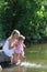 Mother and her little daughter squirting water at the lake