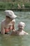 Mother with her little daughter swimming. Summer holidays with children. Two-year-old girl splashes in the water and laughs