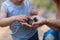 Mother and her little son discovering nature looking on pine-tree cones, close-up