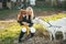 A mother with her red-heired baby daughter feeds a white goat on a farm